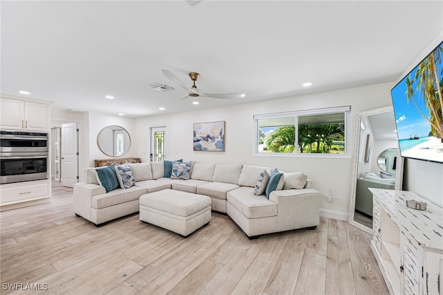 living area with plenty of natural light, visible vents, light wood-type flooring, and a ceiling fan