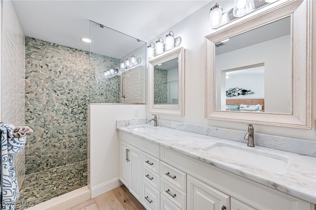 full bathroom with double vanity, walk in shower, wood finished floors, and a sink