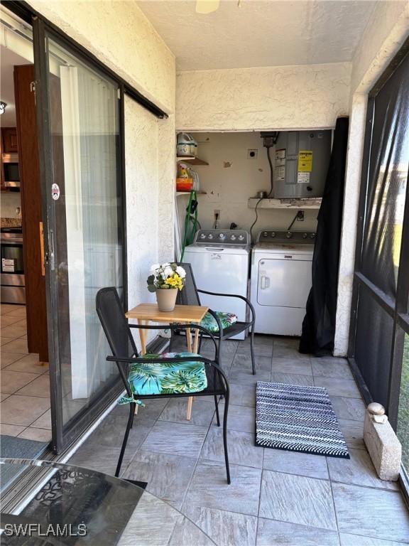 4903 Vincennes St Unit 116, Cape Coral, FL 33904 - laundry area featuring electric panel, washing machine and clothes dryer, laundry area, and a textured wall