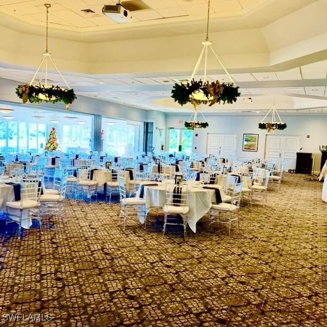 interior space featuring a raised ceiling, a notable chandelier, and carpet floors