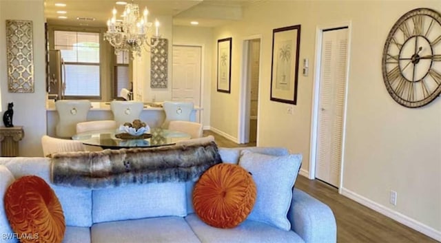 living area with wood finished floors, baseboards, and a chandelier