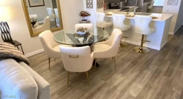 dining area featuring baseboards and dark wood-style flooring