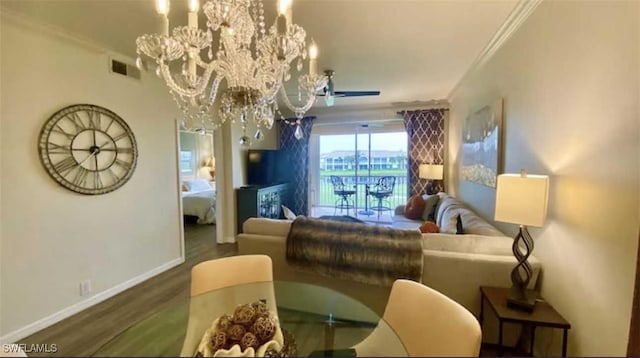 living room featuring visible vents, ornamental molding, wood finished floors, an inviting chandelier, and baseboards