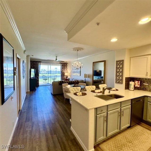 kitchen featuring open floor plan, dishwasher, ornamental molding, a peninsula, and a sink