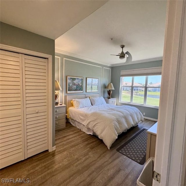 bedroom with a closet, crown molding, a ceiling fan, and dark wood-style flooring