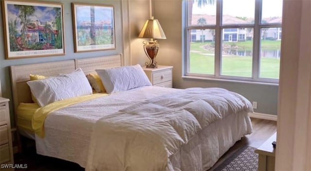 bedroom with baseboards and wood finished floors