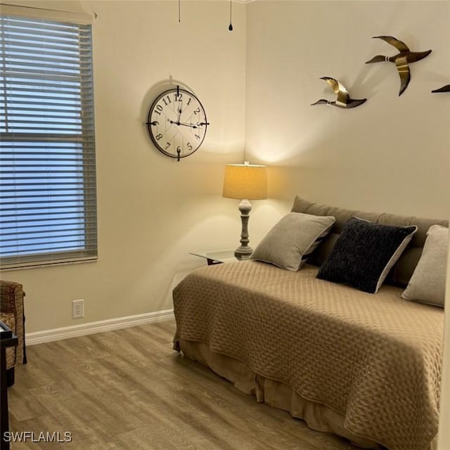 bedroom with baseboards and wood finished floors