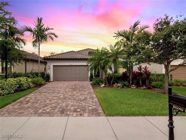 20240 Black Tree Ln, Estero, FL 33928 - view of front of house featuring a tile roof, stucco siding, a lawn, decorative driveway, and an attached garage