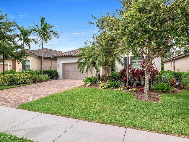 20240 Black Tree Ln, Estero, FL 33928 - view of front of house with a front lawn, an attached garage, driveway, and stucco siding