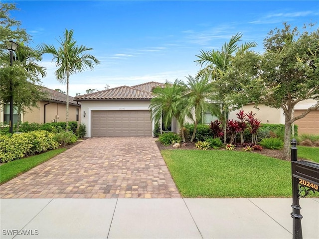 20240 Black Tree Ln, Estero, FL 33928 - view of front facade with stucco siding, a tile roof, decorative driveway, a front yard, and a garage