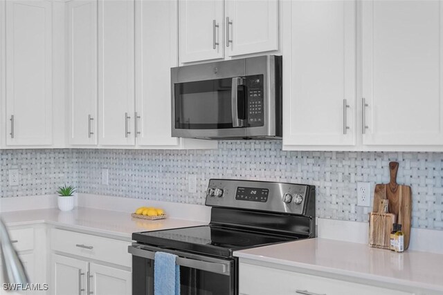 6058 National Blvd Unit 327, Ave Maria, FL 34142 - kitchen featuring decorative backsplash, light countertops, white cabinets, and appliances with stainless steel finishes