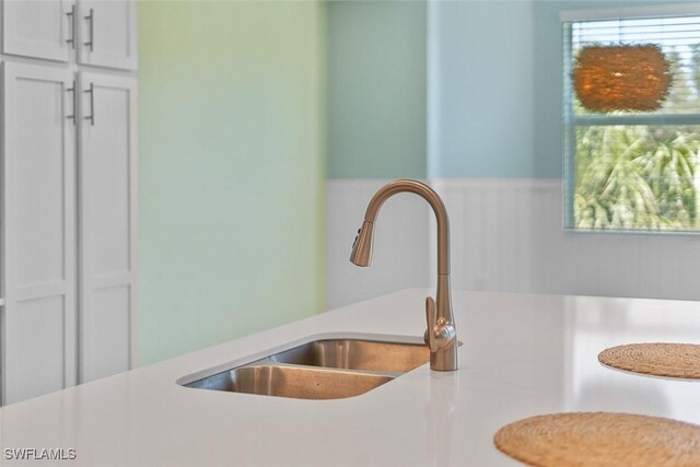 6058 National Blvd Unit 327, Ave Maria, FL 34142 - room details featuring wainscoting, white cabinetry, light countertops, and a sink
