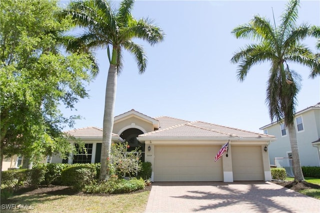 2604 Stonyhill Ct, Cape Coral, FL 33991 - ranch-style home with a tiled roof, a garage, stucco siding, and decorative driveway