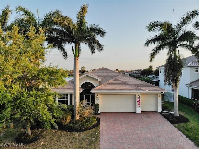 2604 Stonyhill Ct, Cape Coral, FL 33991 - view of front facade with stucco siding, a tiled roof, decorative driveway, and an attached garage