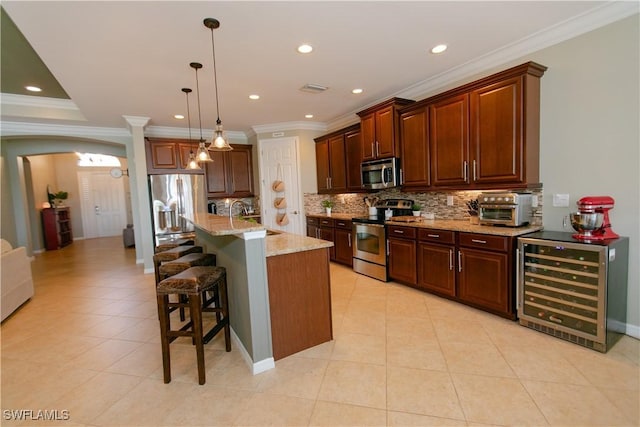 2604 Stonyhill Ct, Cape Coral, FL 33991 - kitchen with backsplash, a kitchen bar, wine cooler, stainless steel appliances, and a sink
