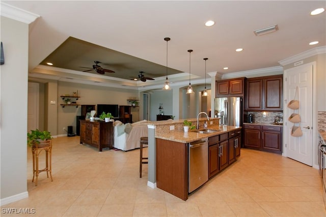 2604 Stonyhill Ct, Cape Coral, FL 33991 - kitchen with a sink, appliances with stainless steel finishes, a kitchen bar, crown molding, and backsplash