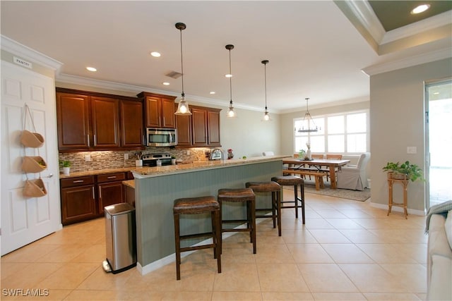 2604 Stonyhill Ct, Cape Coral, FL 33991 - kitchen featuring tasteful backsplash, visible vents, ornamental molding, stainless steel appliances, and a breakfast bar area