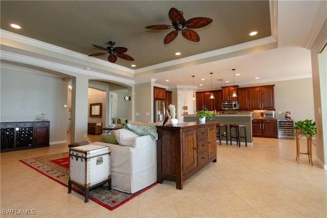 2604 Stonyhill Ct, Cape Coral, FL 33991 - living area with light tile patterned floors, arched walkways, a ceiling fan, wine cooler, and a tray ceiling