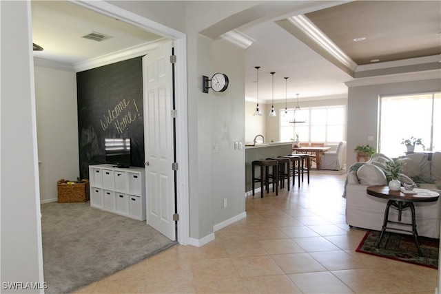 2604 Stonyhill Ct, Cape Coral, FL 33991 - living area with visible vents, baseboards, light tile patterned floors, ornamental molding, and a tray ceiling