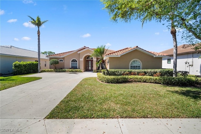 9846 Weather Stone Pl, Fort Myers, FL 33913 - mediterranean / spanish house featuring stucco siding, a front lawn, concrete driveway, and a tile roof