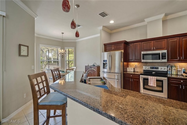 9846 Weather Stone Pl, Fort Myers, FL 33913 - kitchen with appliances with stainless steel finishes, tasteful backsplash, light tile patterned floors, a chandelier, and a kitchen bar