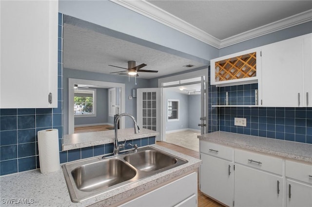 290 Granada Blvd, Fort Myers, FL 33905 - kitchen with white cabinetry, light countertops, a textured ceiling, decorative backsplash, and a sink