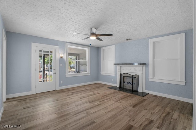 290 Granada Blvd, Fort Myers, FL 33905 - unfurnished living room with visible vents, baseboards, ceiling fan, wood finished floors, and a fireplace with raised hearth