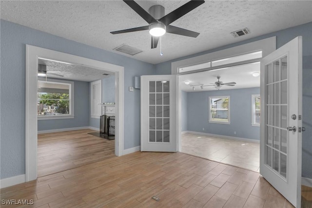 290 Granada Blvd, Fort Myers, FL 33905 - spare room featuring a healthy amount of sunlight, wood finished floors, french doors, and a ceiling fan