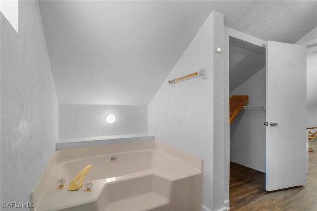290 Granada Blvd, Fort Myers, FL 33905 - full bath featuring a spacious closet, a garden tub, vaulted ceiling, and wood finished floors