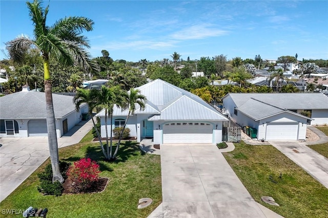 41 5th St, Bonita Springs, FL 34134 - ranch-style house with a front yard, concrete driveway, stucco siding, and an attached garage