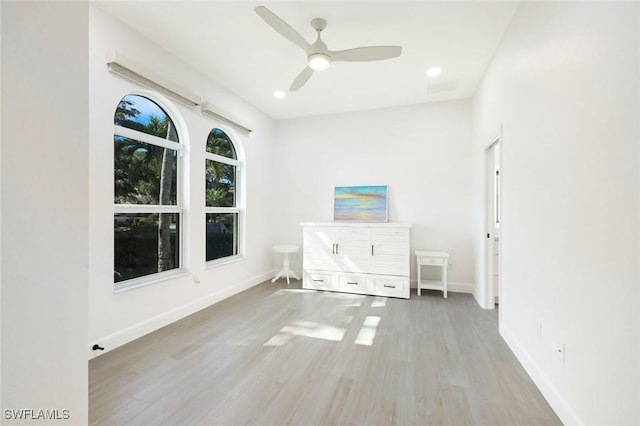 unfurnished room with a ceiling fan, wood finished floors, and baseboards