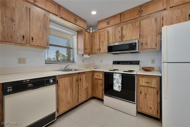 4146 27th Ct SW Unit 204, Naples, FL 34116 - kitchen with white appliances, light countertops, light flooring, a textured ceiling, and brown cabinets