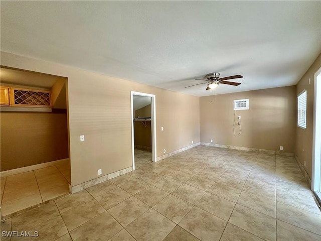 1434 Alhambra Dr, Fort Myers, FL 33901 - empty room with a wall mounted air conditioner, ceiling fan, baseboards, and light tile patterned floors
