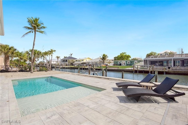 outdoor pool featuring a residential view, a water view, a patio, and a dock