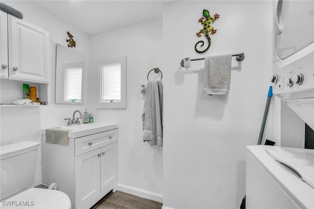 bathroom with toilet, wood finished floors, vanity, and baseboards