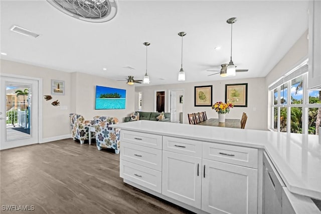 kitchen with a ceiling fan, dark wood finished floors, visible vents, white cabinets, and a peninsula