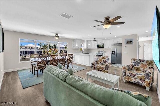 living area featuring light wood-type flooring, recessed lighting, baseboards, visible vents, and a ceiling fan