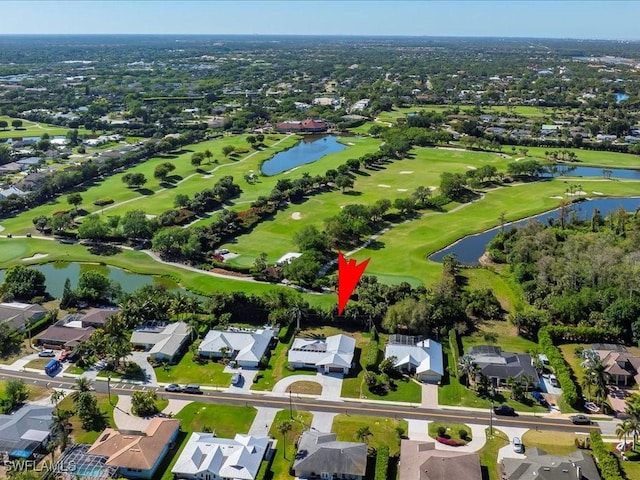 drone / aerial view with golf course view, a residential view, and a water view