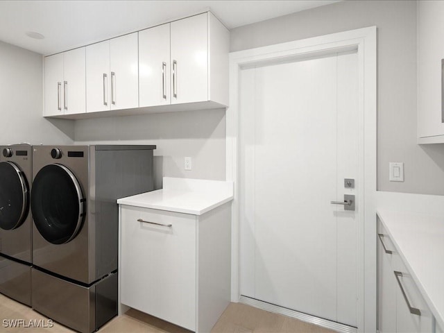 washroom with separate washer and dryer and cabinet space