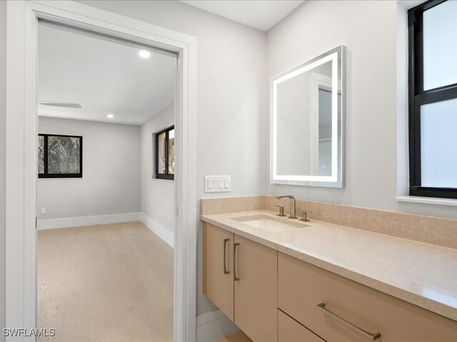 bathroom featuring vanity, recessed lighting, and baseboards