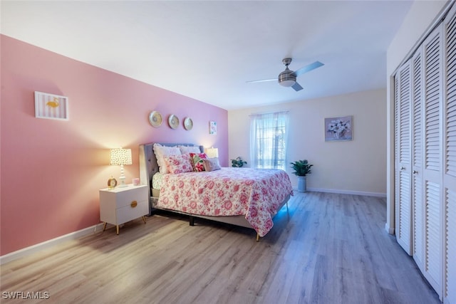 bedroom featuring a closet, baseboards, wood finished floors, and a ceiling fan