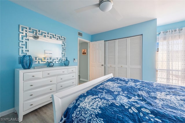 bedroom featuring visible vents, baseboards, wood finished floors, a closet, and a ceiling fan