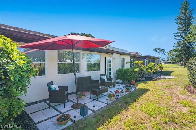 exterior space featuring outdoor lounge area, a patio, a lawn, and stucco siding