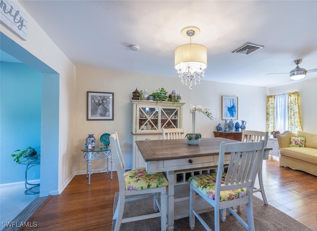 dining area with visible vents, baseboards, an inviting chandelier, and wood finished floors