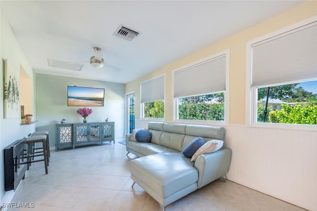 living room featuring light tile patterned floors, visible vents, and ceiling fan