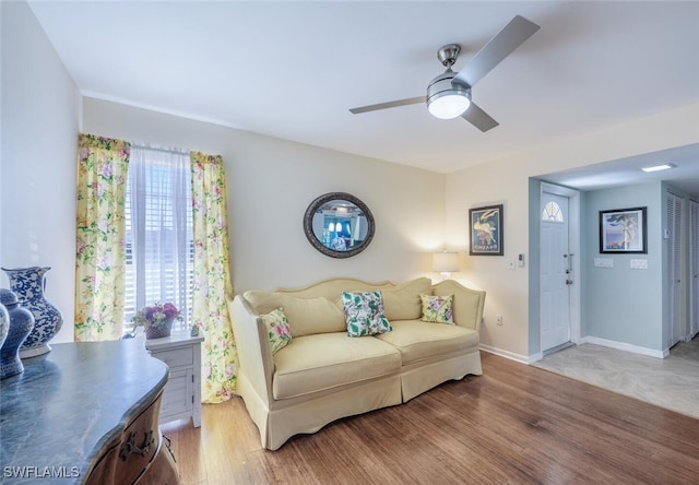 living room with baseboards, a ceiling fan, and wood finished floors