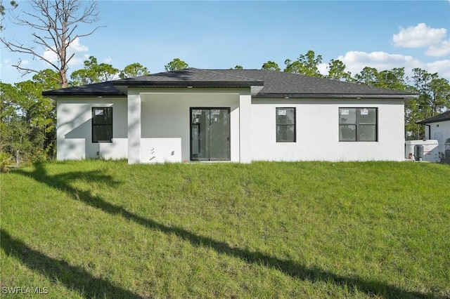 back of house with a yard and stucco siding