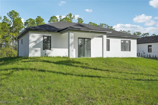 rear view of house with a yard and stucco siding