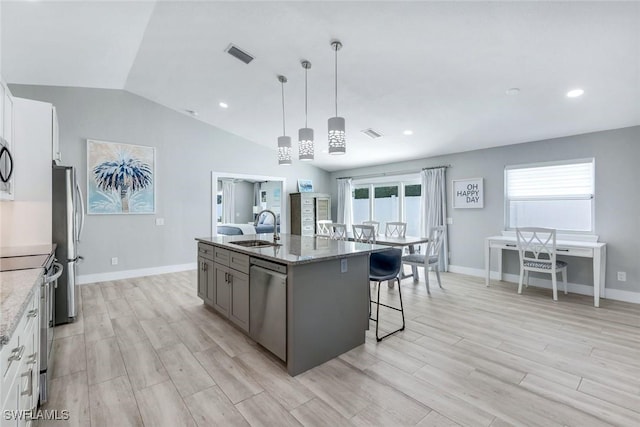 820 102nd Ave N, Naples, FL 34108 - kitchen with light stone counters, a sink, a breakfast bar, appliances with stainless steel finishes, and visible vents
