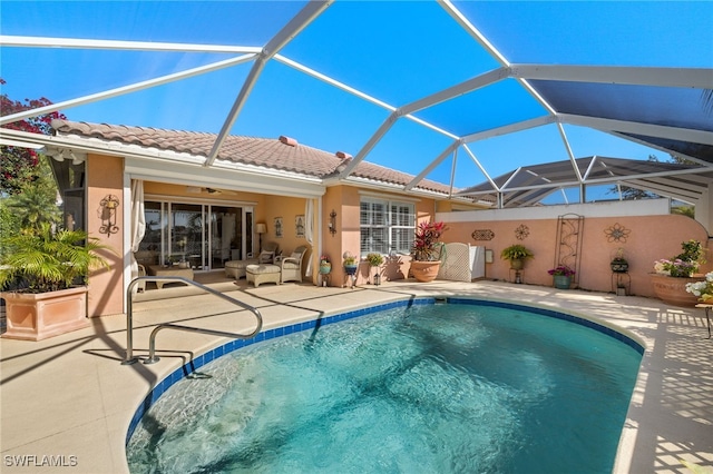 pool featuring ceiling fan, glass enclosure, and a patio